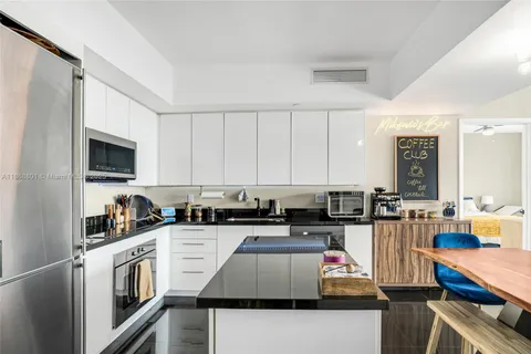 a kitchen with stainless steel appliances granite countertop a stove top oven a sink dishwasher and cabinets with wooden floor