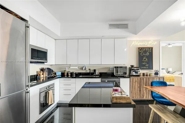 a kitchen with stainless steel appliances granite countertop a stove top oven a sink dishwasher and cabinets with wooden floor