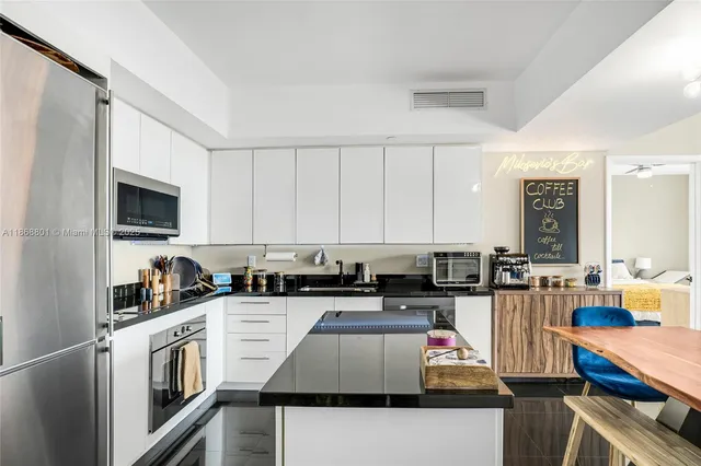 a kitchen with stainless steel appliances granite countertop a stove top oven a sink dishwasher and cabinets with wooden floor