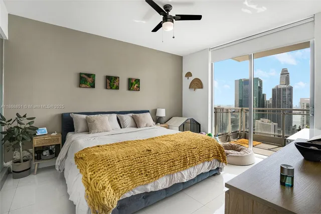 a bedroom with a large bed and a potted plant