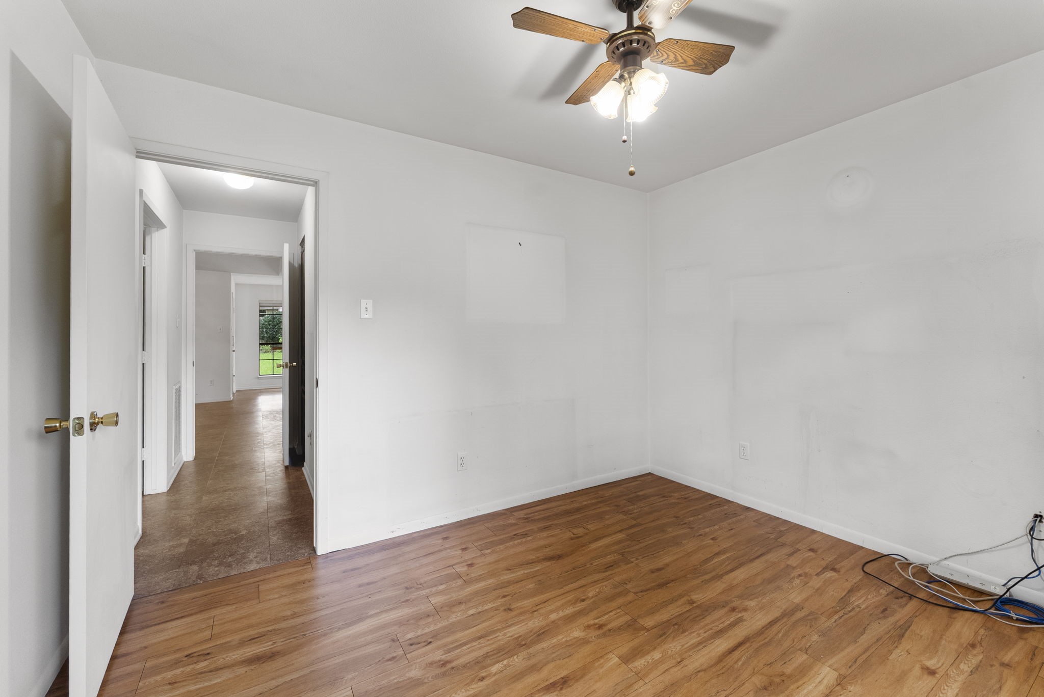 202 Sunset Boulevard Conroe, TX 77303 - Photo 29 of 50 This inviting guest bedroom features warm floors, a ceiling fan for comfort, and easy access to the rest of the home through a bright, open hallway.