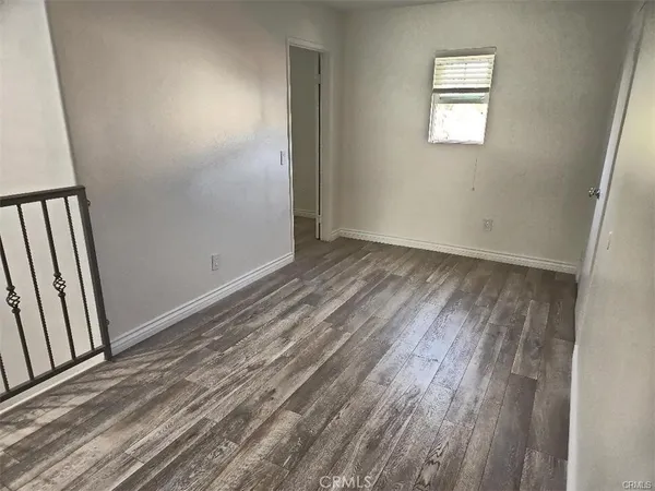 a view of a room with wooden floor and window