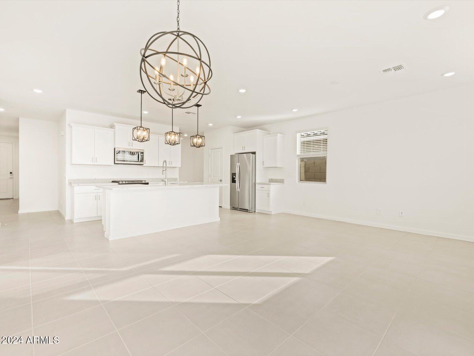 16033 West Hackamore Drive Surprise, AZ 85387 - Photo 16 of 62 a view of a kitchen with a sink and dishwasher a refrigerator with white cabinets
