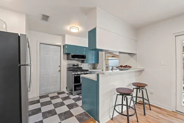 a kitchen with stainless steel appliances a refrigerator a stove a sink and a refrigerator