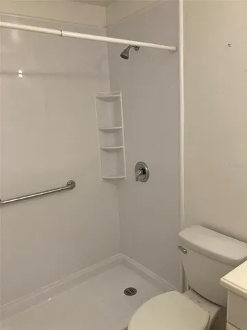 a bathroom with a granite countertop toilet and a sink