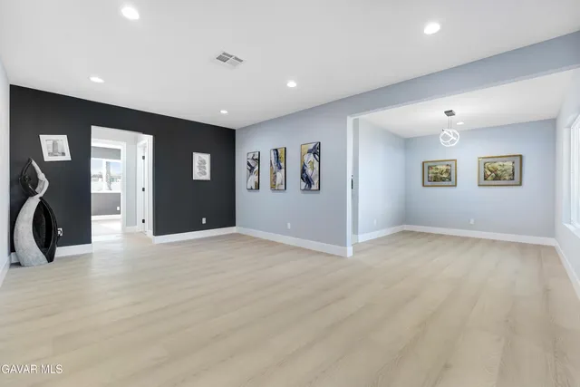 a view of kitchen with stainless steel appliances granite countertop a stove top oven a sink and dishwasher with wooden floor