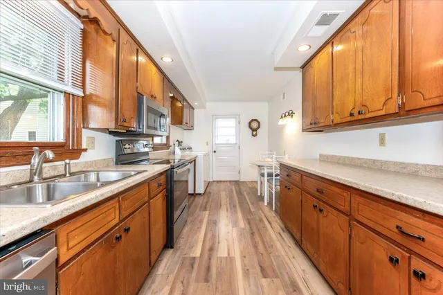 a large kitchen with stainless steel appliances granite countertop a lot of counter space and a sink