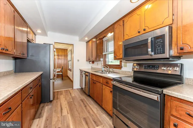 a kitchen with stainless steel appliances granite countertop a stove a sink and a microwave