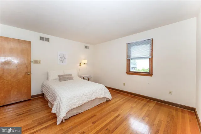 a bedroom with a bed and closet with wooden floor