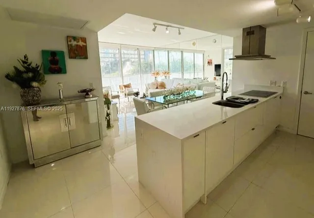 a kitchen with stainless steel appliances granite countertop a stove a sink a refrigerator and a granite counter top