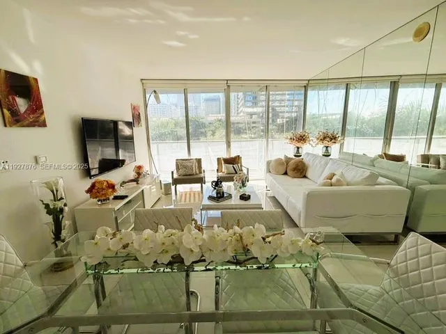 a living room with furniture large window and a flat screen tv