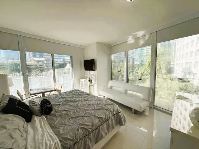 a bedroom with a bed and a large window