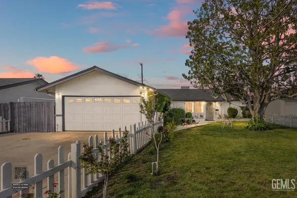 a front view of house with yard and trees in the background