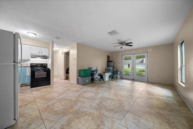 a view of a kitchen with refrigerator and chairs