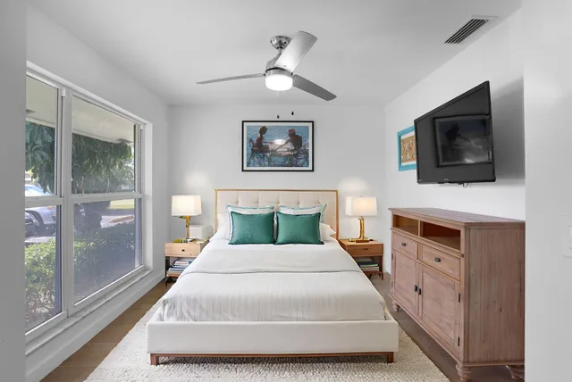 a bedroom with a large bed and a flat screen tv