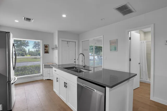 a kitchen with stainless steel appliances granite countertop a sink stove and refrigerator