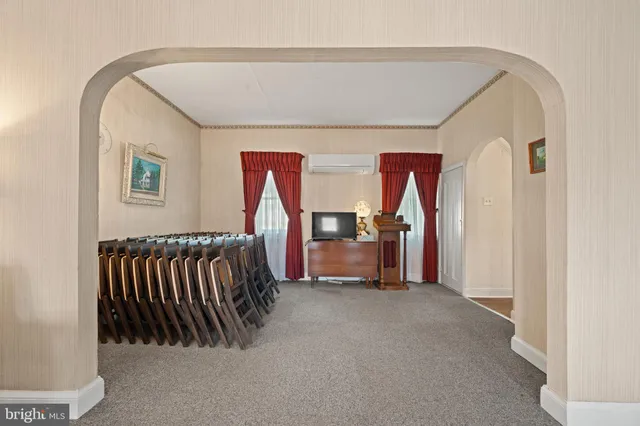 a living room with furniture a dining table and a refrigerator
