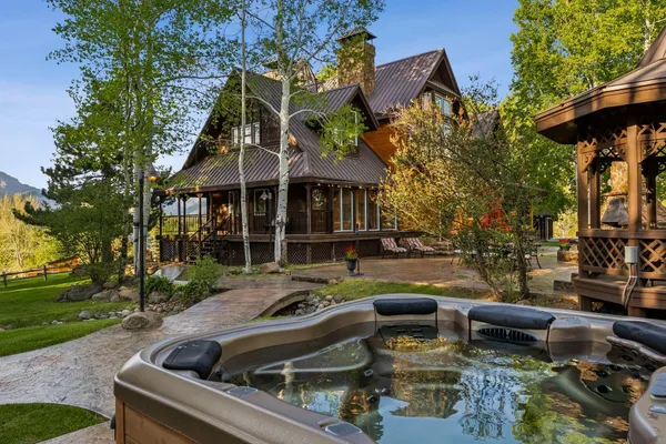 a roof deck with table and chairs and potted plants