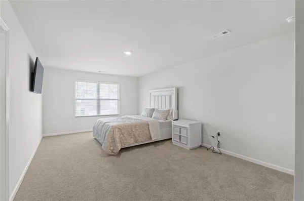 a spacious bedroom with a bed and a window