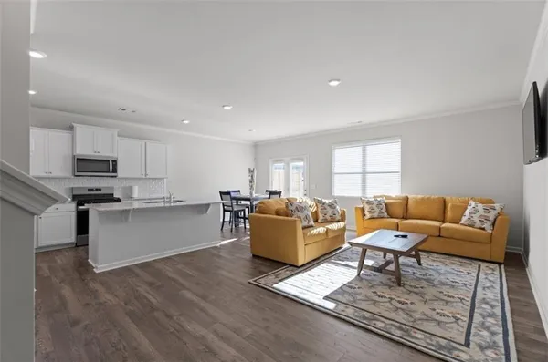 a living room with furniture and kitchen view