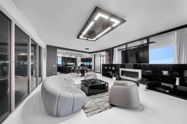 a living room with furniture kitchen view and a large window