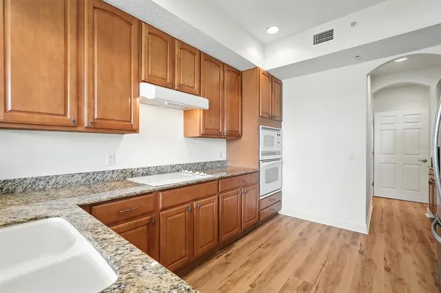 a kitchen with granite countertop cabinets stainless steel appliances and a sink