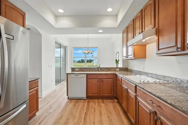 a kitchen with granite countertop cabinets and wooden floor