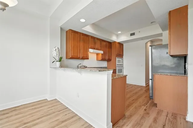 a kitchen with granite countertop wooden cabinets a sink and dishwasher