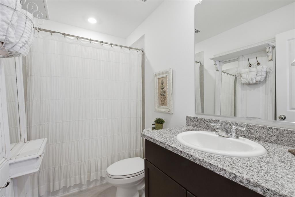5969 Sumlin Way Princeton, TX 75407 - Photo 17 of 26 a bathroom with a granite countertop sink toilet and shower