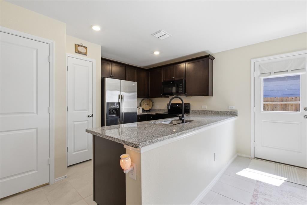 5969 Sumlin Way Princeton, TX 75407 - Photo 10 of 26 a kitchen with stainless steel appliances granite countertop a sink a refrigerator and a granite counter tops