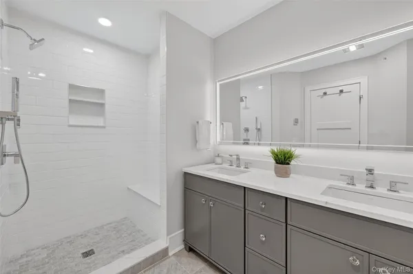 a bathroom with a granite countertop sink mirror and shower
