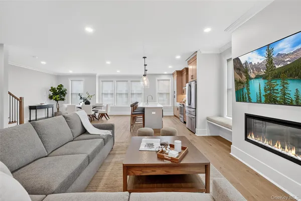 a living room with furniture kitchen view and a large window