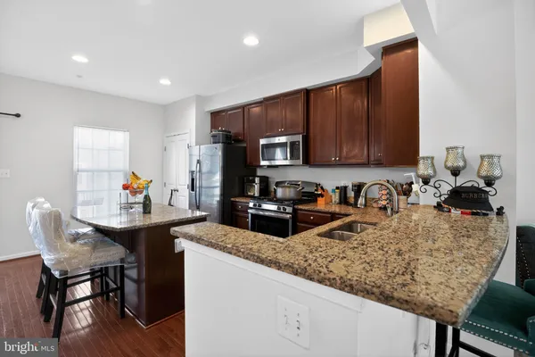 a kitchen with granite countertop kitchen island stainless steel appliances a sink table and chairs