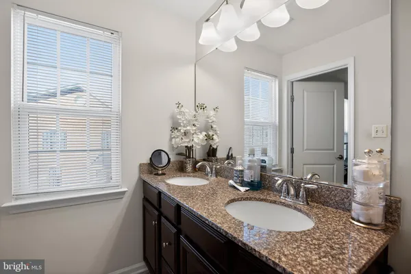 a bathroom with a granite countertop sink a large mirror and a window