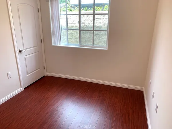 an empty room with wooden floor and window