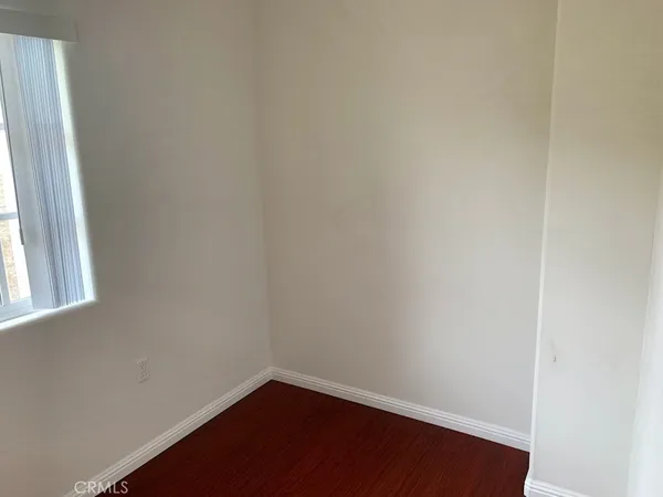 a view of a small space with wooden floor and a window
