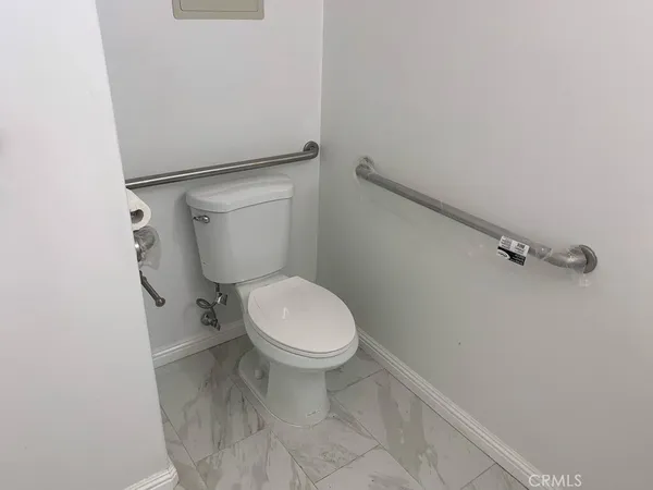 a white toilet sitting next to a white cabinet