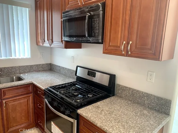 a kitchen with wooden cabinets and a stove top oven