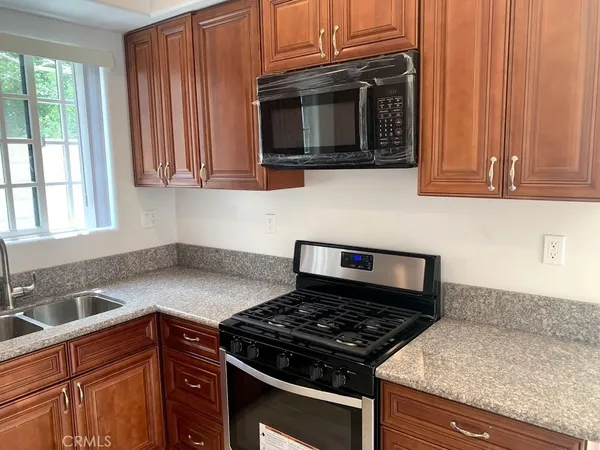 a kitchen with granite countertop a stove and a sink