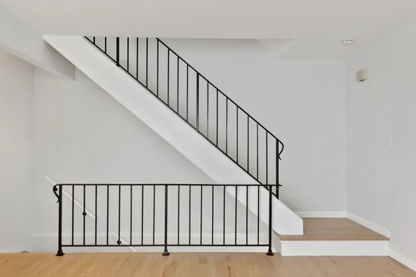 a view of staircase with white walls and a window