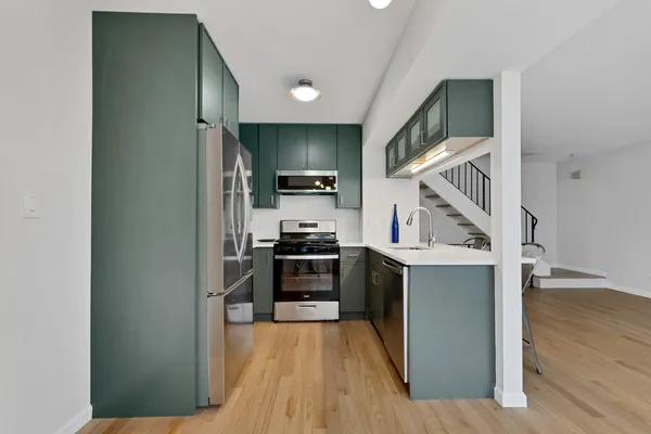 a kitchen with stainless steel appliances granite countertop a refrigerator and a stove top oven