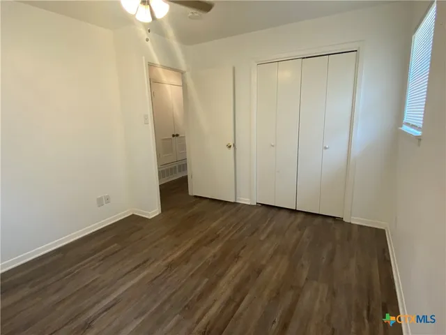 a view of an empty room with wooden floor