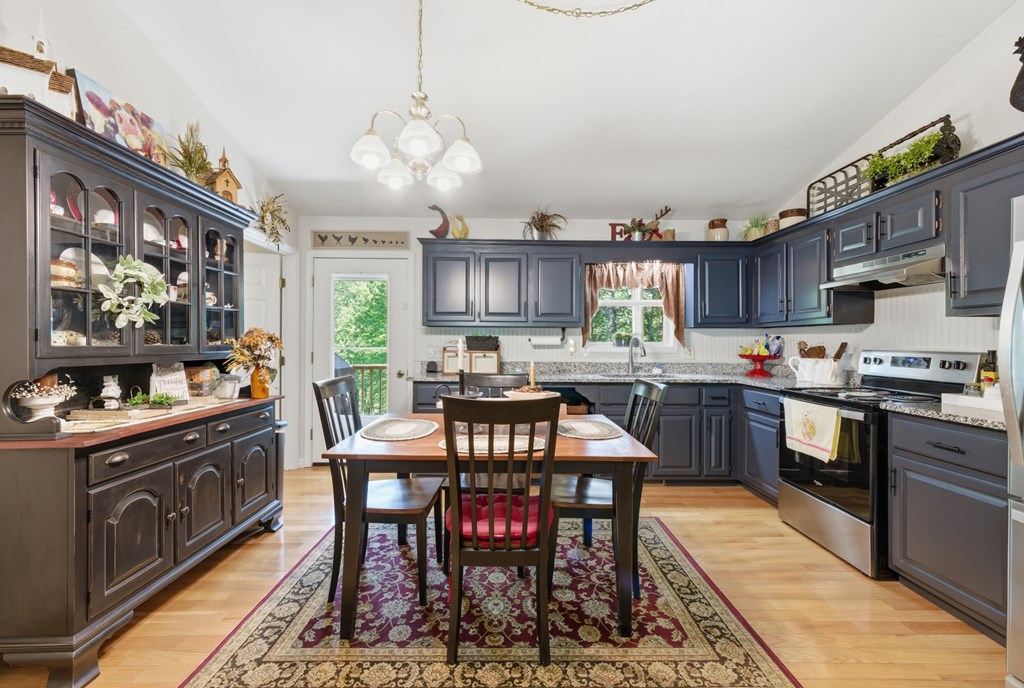 68 West Vineyard Road Hayesville, NC 28904 - Photo 24 of 46 a kitchen with stainless steel appliances granite countertop a stove a sink dishwasher a dining table and chairs with wooden floor
