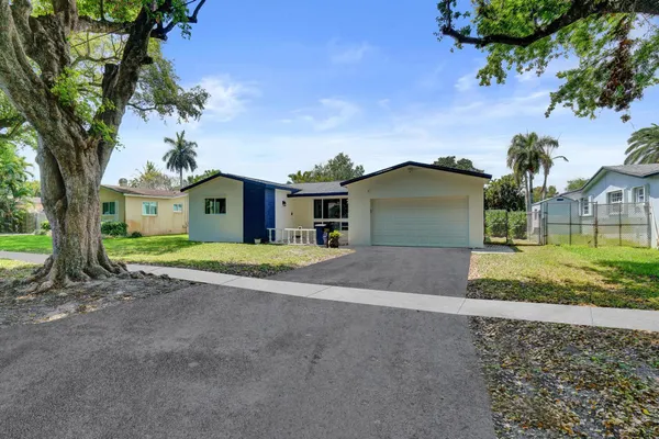 front view of a house with a yard and an trees