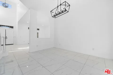 a living room with furniture potted plant and a large window