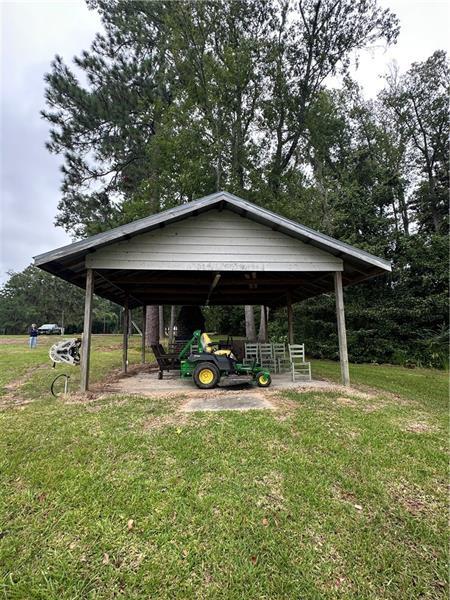 631 Flintside Drive Cobb, GA 31735 - Photo 2 of 6 a backyard of a house with table and chairs under an umbrella