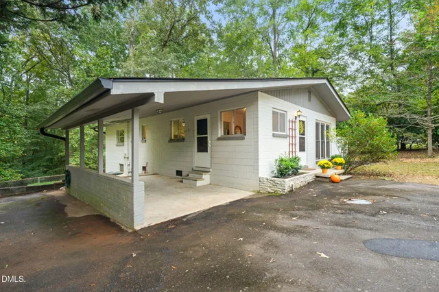 a view of a house with a patio and a yard
