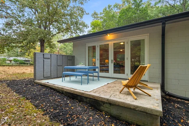 a view of a dinning tables and chairs in the patio in front of a house