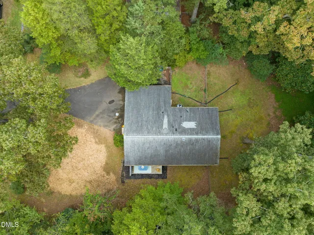 an aerial view of residential houses with outdoor space and trees