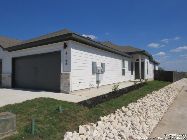 415 Cross Barn Boulevard, Unit B Buda, TX 78610 - Photo 2 of 23 a front view of a house with a yard